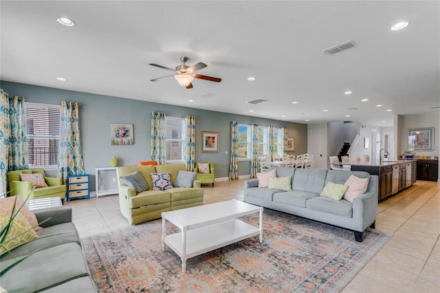 living room featuring light tile patterned flooring, sink, and ceiling fan