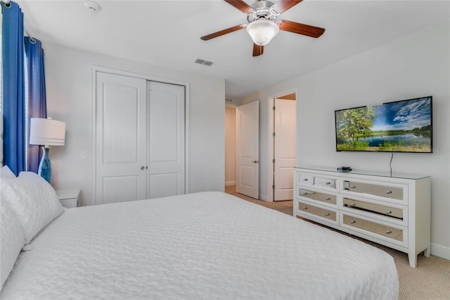 carpeted bedroom featuring ceiling fan and a closet