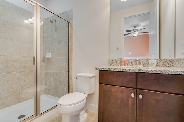 bathroom featuring a shower with door, vanity, ceiling fan, and toilet