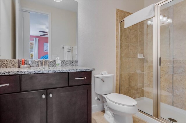 bathroom with walk in shower, vanity, ceiling fan, and toilet