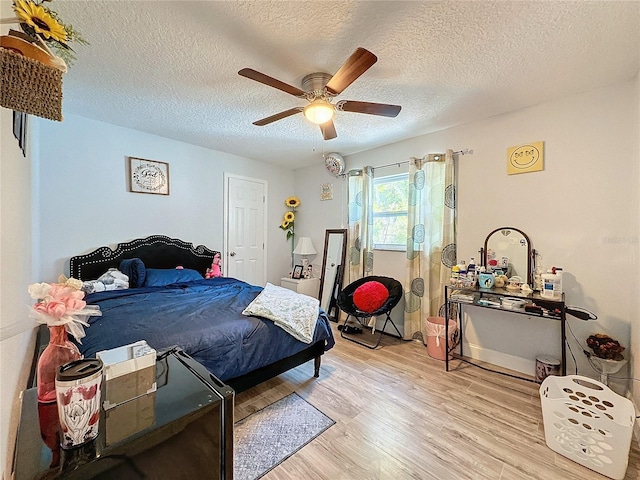 bedroom with a textured ceiling, light hardwood / wood-style flooring, and ceiling fan