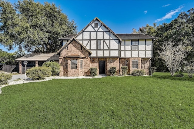 tudor-style house featuring a front yard