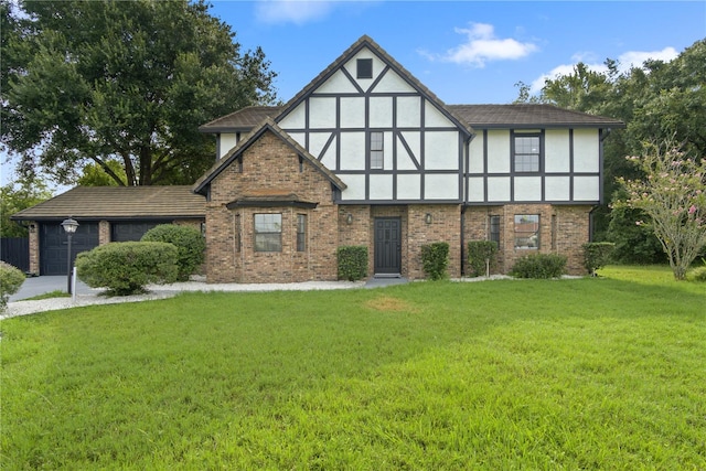 tudor home featuring a garage and a front lawn