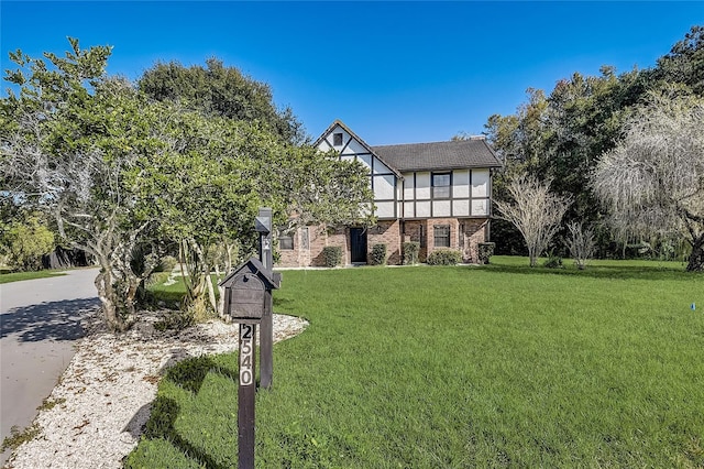 english style home featuring a front yard