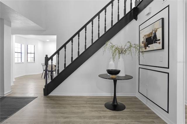 stairway featuring hardwood / wood-style floors and a textured ceiling