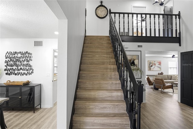 staircase with hardwood / wood-style flooring and a textured ceiling