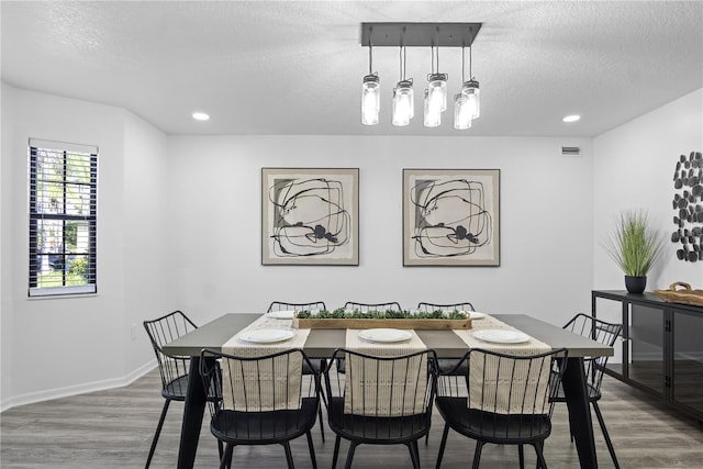 dining room with hardwood / wood-style flooring and a textured ceiling