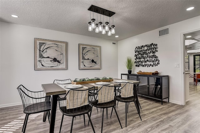 dining area featuring a textured ceiling and wood-type flooring