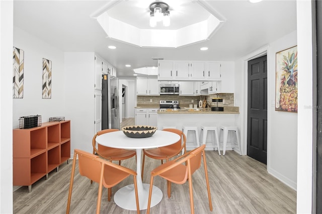 dining area with ceiling fan and light hardwood / wood-style flooring