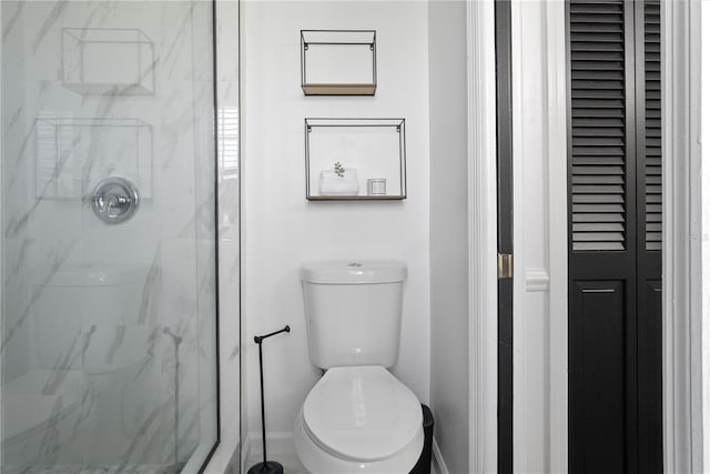 bathroom featuring tiled shower and toilet