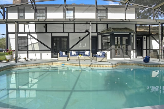 view of swimming pool with glass enclosure, an outdoor living space, and french doors