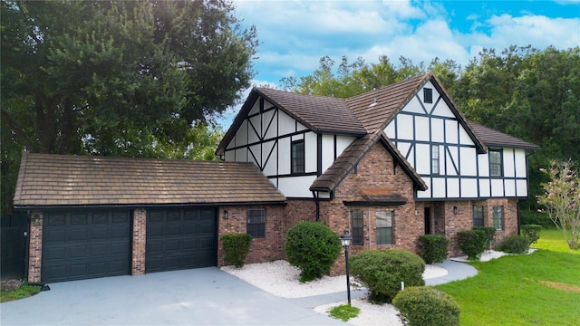 tudor home with a garage and a front yard