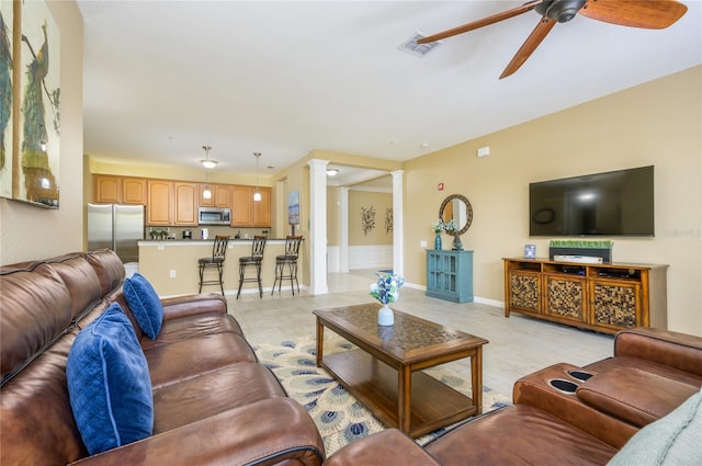 living room featuring ceiling fan and ornate columns