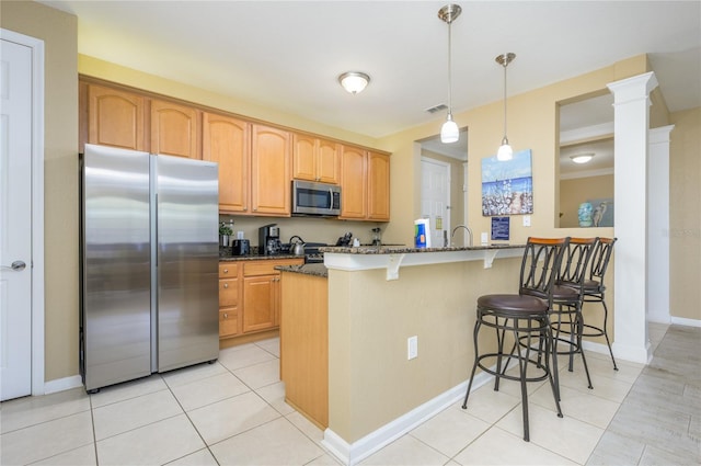 5012 Shoreway Loop Unit 10207, Orlando, FL 32819 - kitchen featuring appliances with stainless steel finishes, a kitchen breakfast bar, dark stone counters, pendant lighting, and light tile patterned flooring