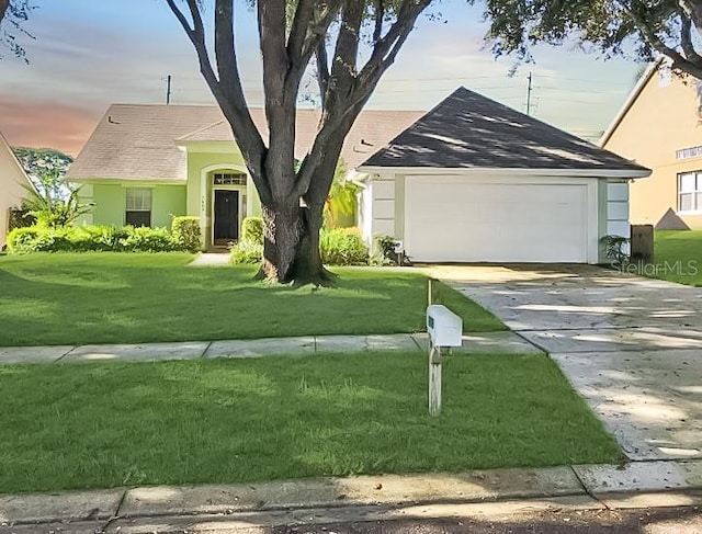 ranch-style house featuring a garage and a lawn