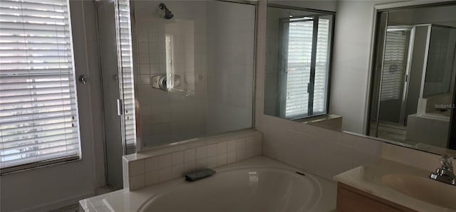 bathroom with shower with separate bathtub and vanity