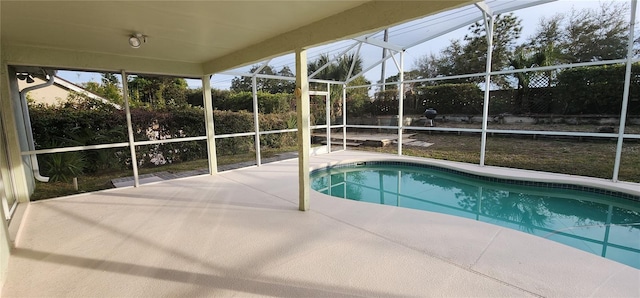 view of pool with glass enclosure and a patio area