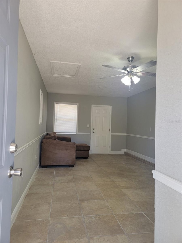 unfurnished room featuring ceiling fan and a textured ceiling