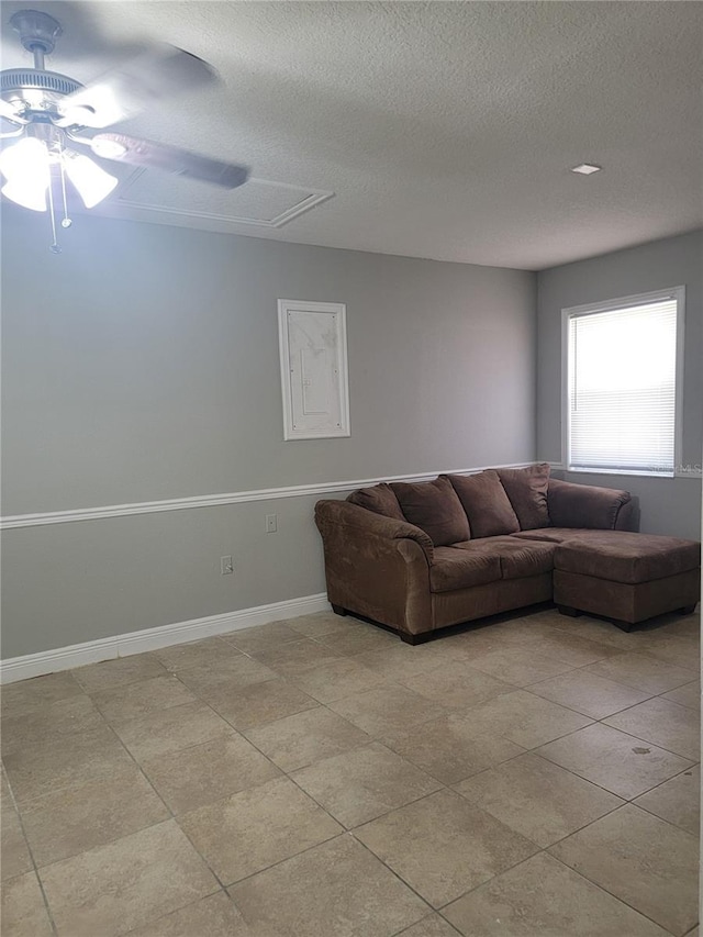 tiled living room with ceiling fan and a textured ceiling