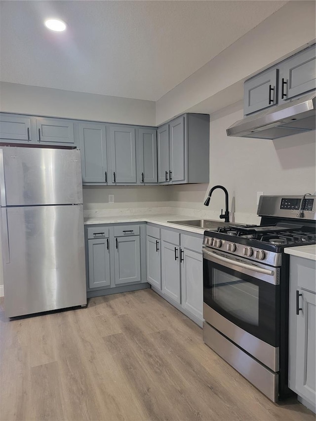 kitchen featuring sink, light hardwood / wood-style flooring, gray cabinetry, and stainless steel appliances