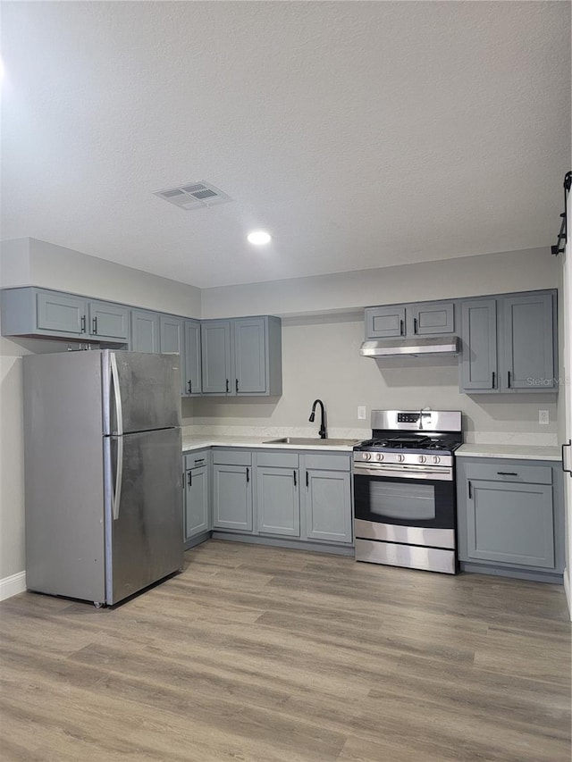 kitchen featuring sink, gray cabinets, light hardwood / wood-style floors, and stainless steel appliances