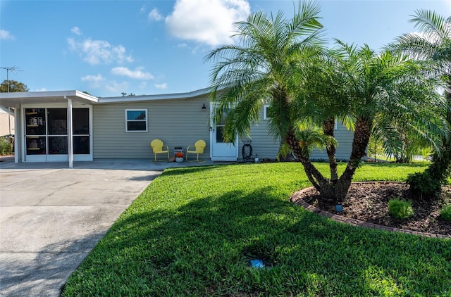 rear view of house with a carport and a lawn