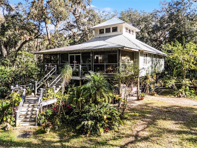 rear view of property featuring a sunroom