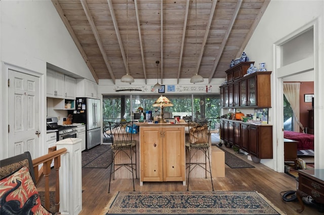 kitchen with wood ceiling, plenty of natural light, a breakfast bar, and appliances with stainless steel finishes