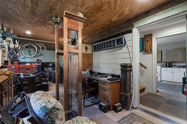 kitchen with concrete flooring, separate washer and dryer, and wood walls