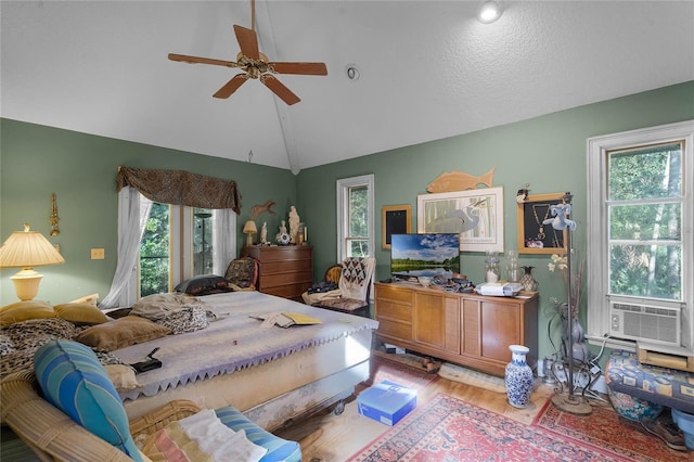 bedroom with cooling unit, ceiling fan, wood-type flooring, and vaulted ceiling