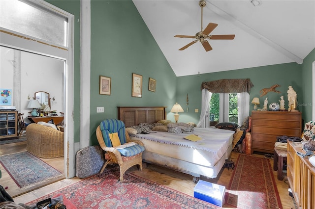 bedroom with hardwood / wood-style flooring, ceiling fan, and high vaulted ceiling