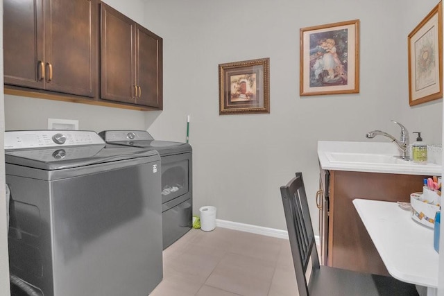 laundry room featuring cabinets, sink, light tile patterned floors, and washing machine and clothes dryer