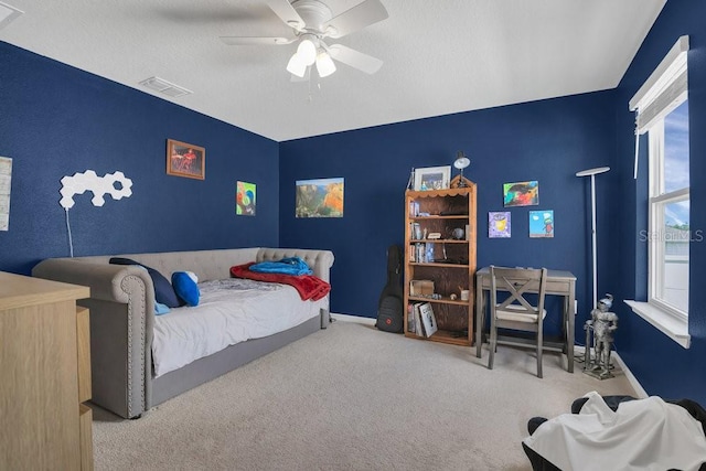 carpeted bedroom featuring a textured ceiling and ceiling fan