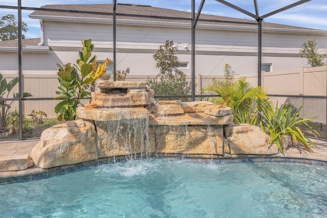 view of pool with pool water feature and a lanai