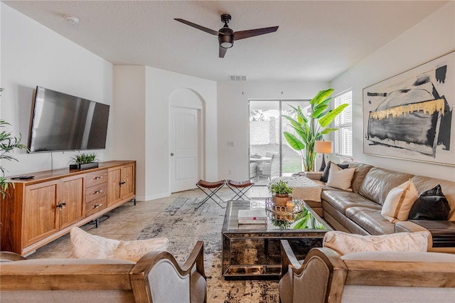 living room featuring ceiling fan, visible vents, and baseboards