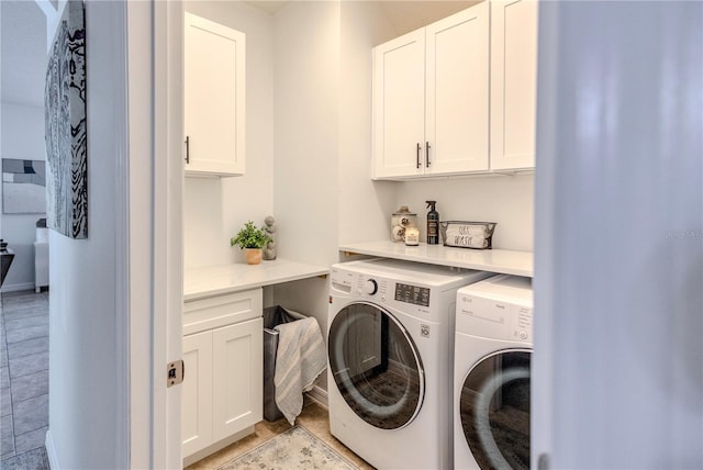 clothes washing area with cabinet space and washing machine and clothes dryer