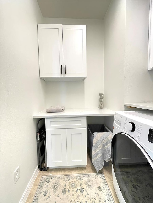 clothes washing area with washer / dryer, baseboards, and cabinet space