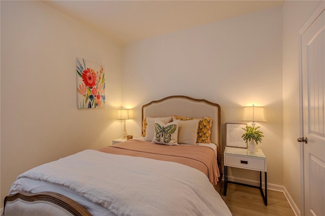 bedroom with wood finished floors and baseboards