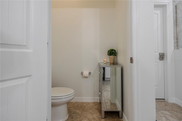 bathroom with tile patterned flooring, toilet, and baseboards