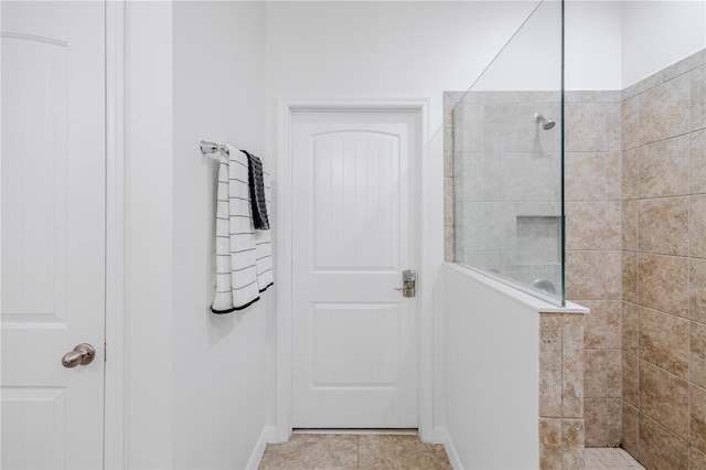 bathroom featuring tile patterned floors, baseboards, and walk in shower