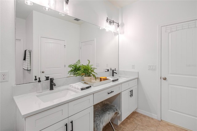 full bath featuring double vanity, a sink, visible vents, and baseboards