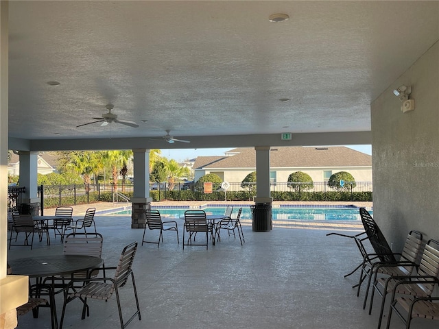 view of patio / terrace featuring fence, a community pool, and ceiling fan