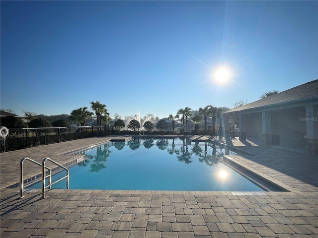 community pool featuring a patio area and fence