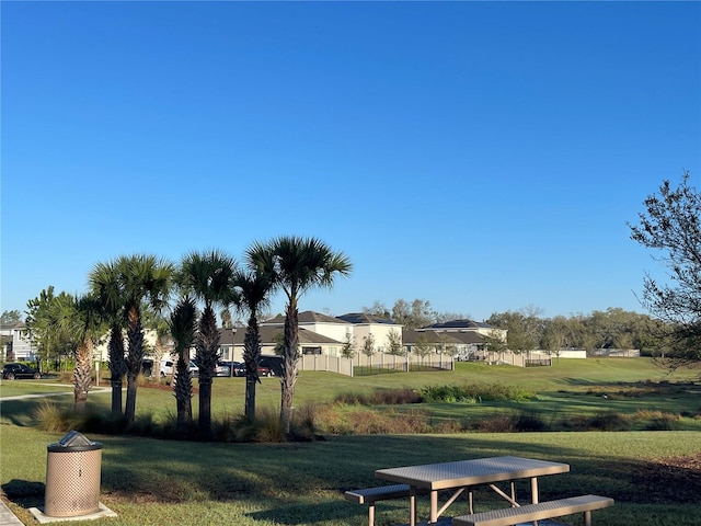 surrounding community with fence and a yard