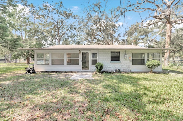 ranch-style home with a sunroom and a front lawn