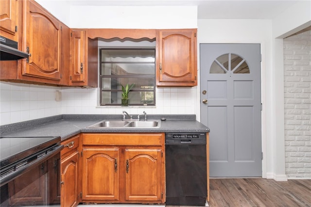 kitchen with black appliances, hardwood / wood-style floors, tasteful backsplash, extractor fan, and sink