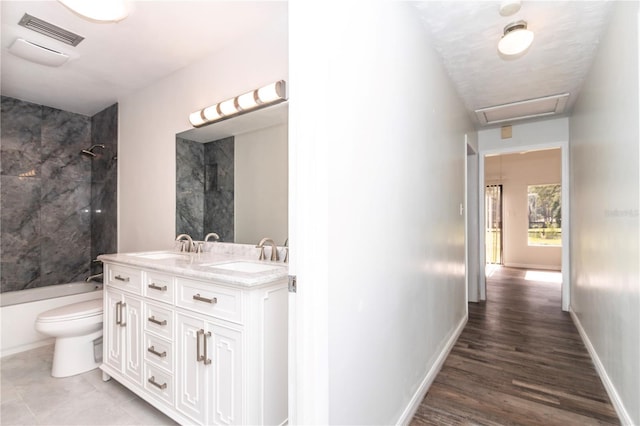 full bathroom featuring tiled shower / bath combo, vanity, and toilet