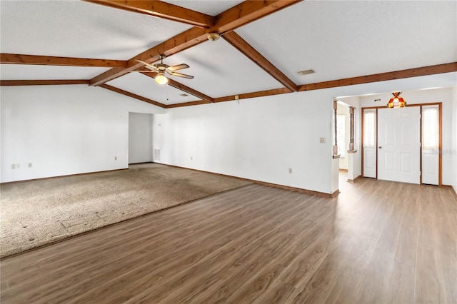 unfurnished living room featuring hardwood / wood-style flooring, lofted ceiling with beams, and ceiling fan