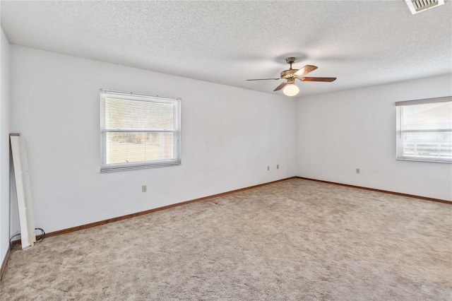 empty room featuring ceiling fan and light colored carpet