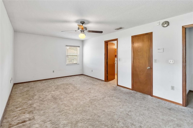 unfurnished bedroom with light carpet, a textured ceiling, and ceiling fan